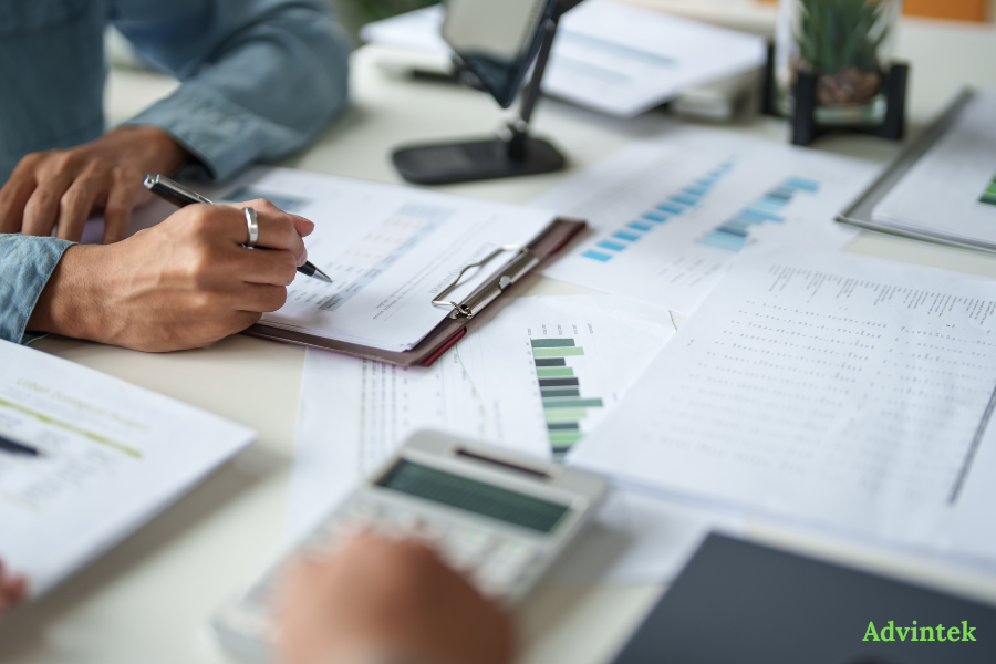 UAE e-Invoicing Guide: PEPPOL Framework, Requirements & Compliance Timeline (2026–2027) 3 Business professionals validating financial records for UAE Peppol E-invoicing compliance readiness