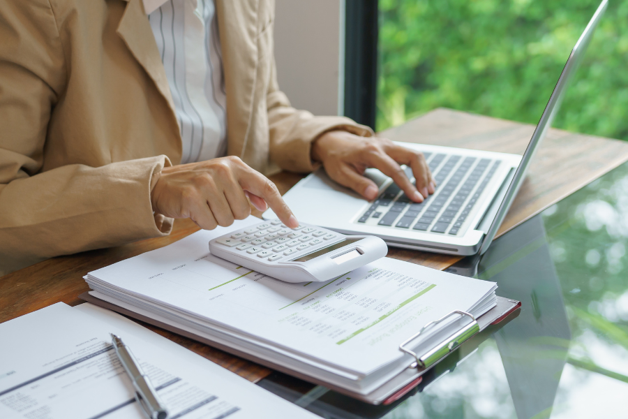 person calculating corporate tax on laptop 